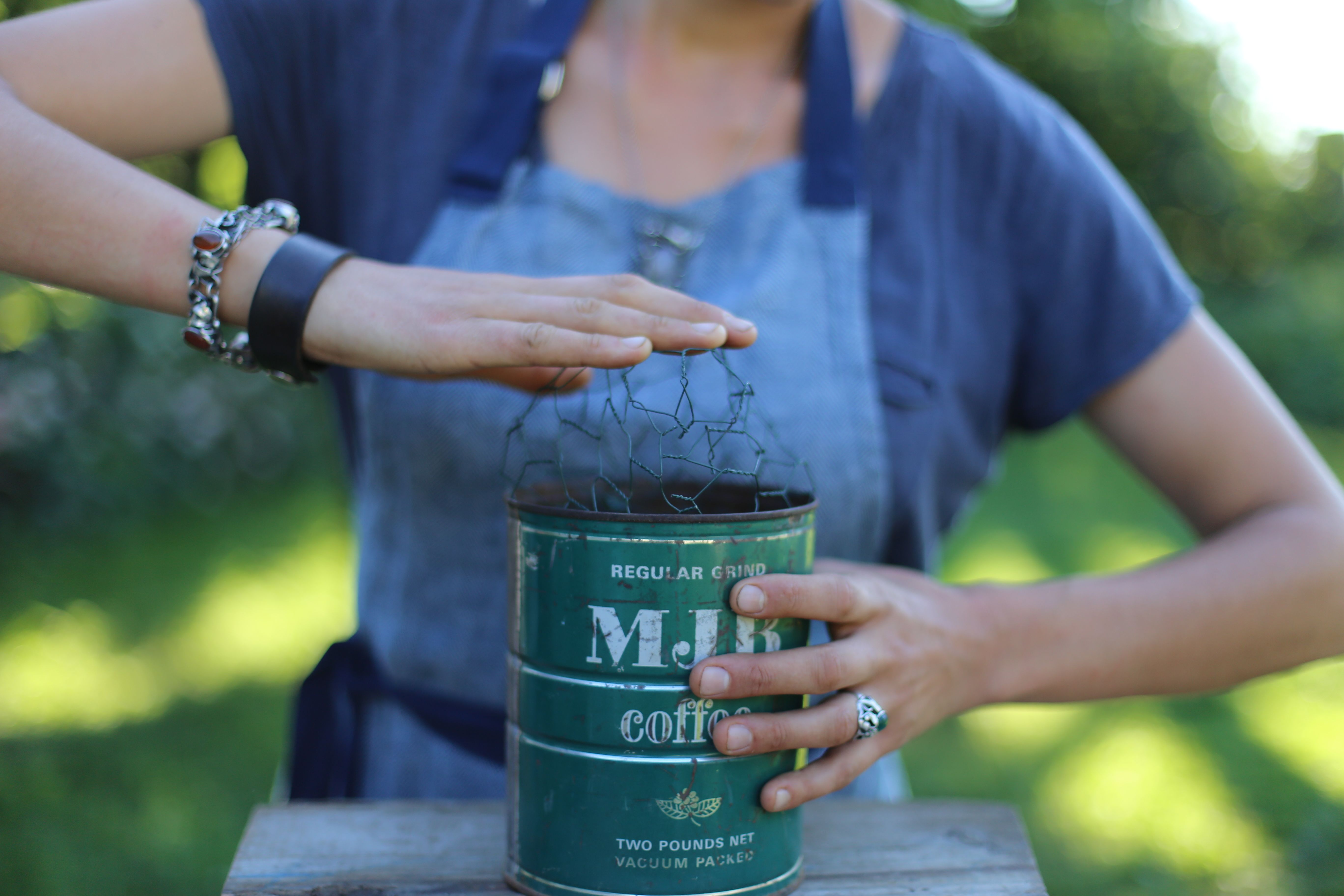 Pushing chicken wire into a coffee can