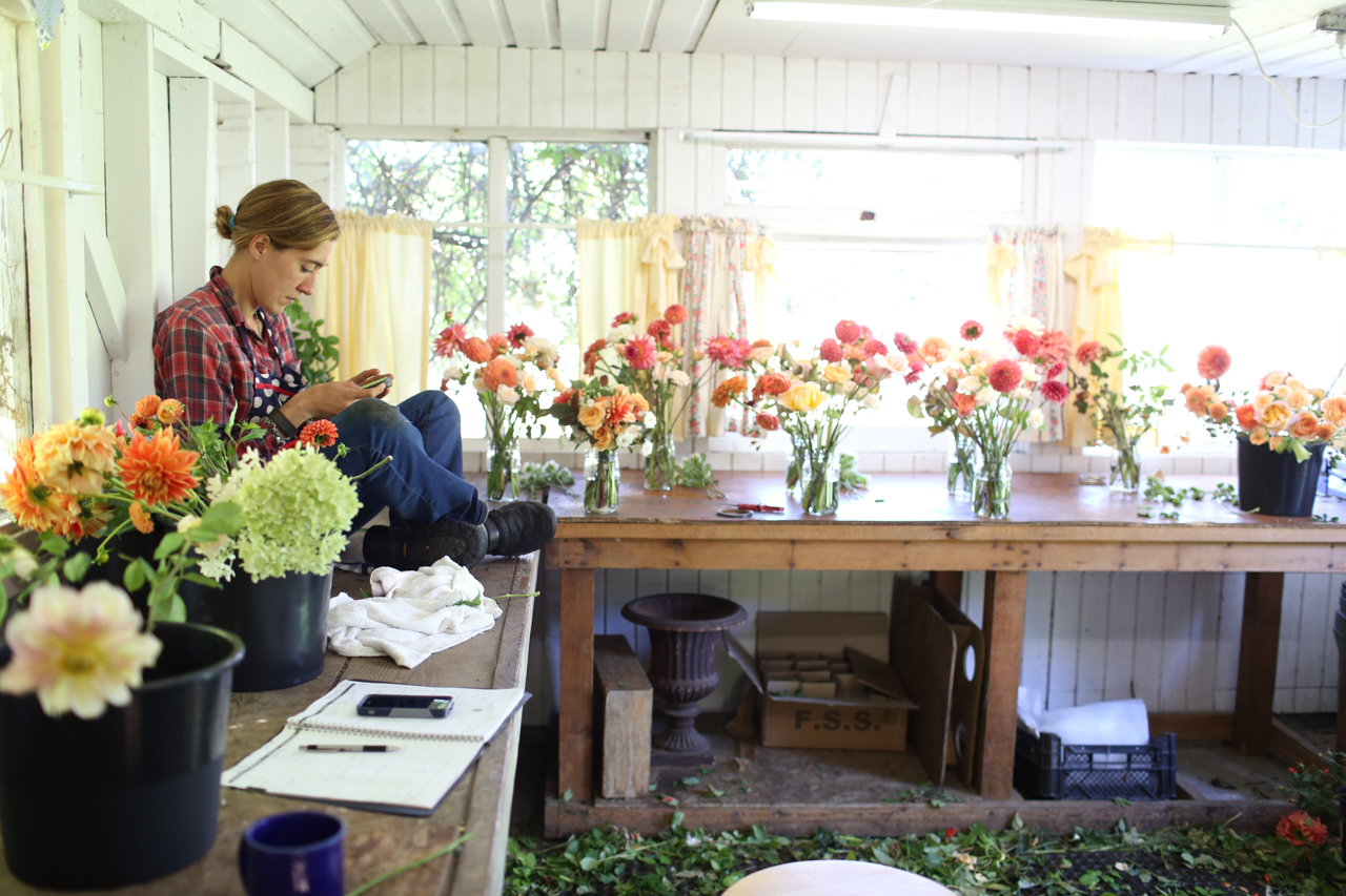 Erin Benzakein looking at her phone in the Floret studio